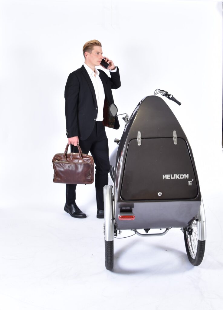 Startseite 9 Mann im Anzug mit Aktentasche neben dem grauen Helikon e°